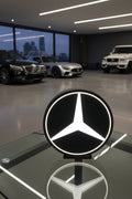 Mercedes-Benz logo light on a dark surface with a blurred background